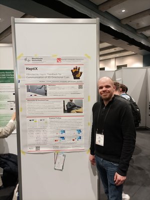Max Pascher presents the poster "HaptiX: Vibrotactile Haptic Feedback for Communication of 3D Directional Cues" at 2023 CHI Conference on Human Factors in Computing Systems in Hamburg, Germany
